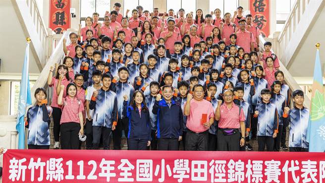 副县长陈见贤（中）与参加全国小学田径锦标赛新竹县代表队选手一起振臂高喊「加油」。（罗浚滨摄）