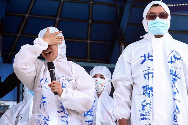 五一劳动节，台湾医疗工会联合会代表，在大让天穿上全套防护装，演出医护人员牺牲家中长辈孩童，甚至本身因公确诊、病房人力不足无法休假，但政府承诺的防疫补偿金、奖励金却全数跳票的剧情，讽刺民进党政府要基层为防疫付出、收割防疫成果，却未履行承诺，给予基层相对应的补偿。（邓博仁摄）
