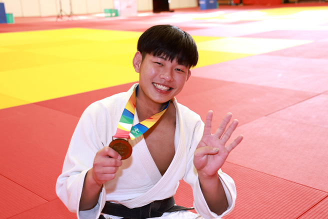 文化大学郑彦忠比出4面金牌手势，代表自己在全大运完成4连霸。（中原大学提供）