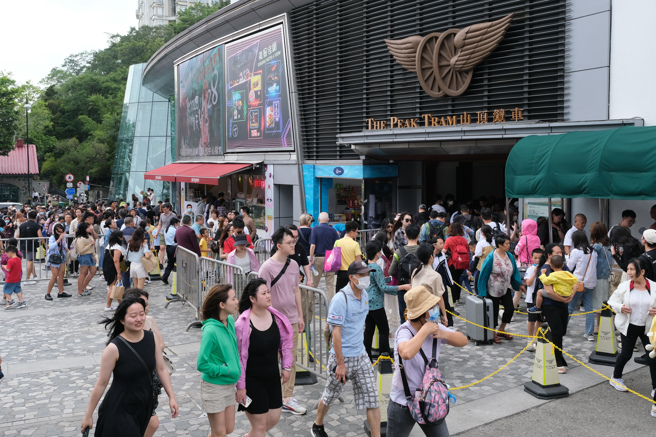  5月1日为劳动节假期，眾多游客前往香港山顶游玩。图为山顶缆车站大排长龙。(中新社)