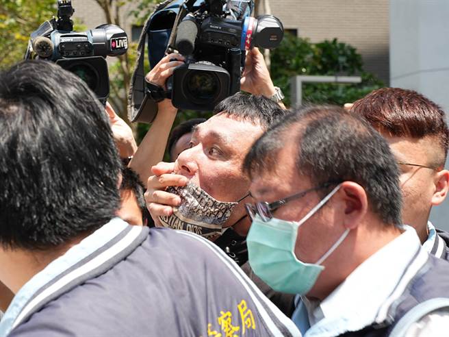 胡姓枪手今(2日)遭移送时不改嚣张气焰，不仅飙骂现场记者，途中不慎遭摄影机撞到头还爆粗口呛声，一度面露凶光、不愿上警车要跟摄影师「输赢」。(黄敬文摄)