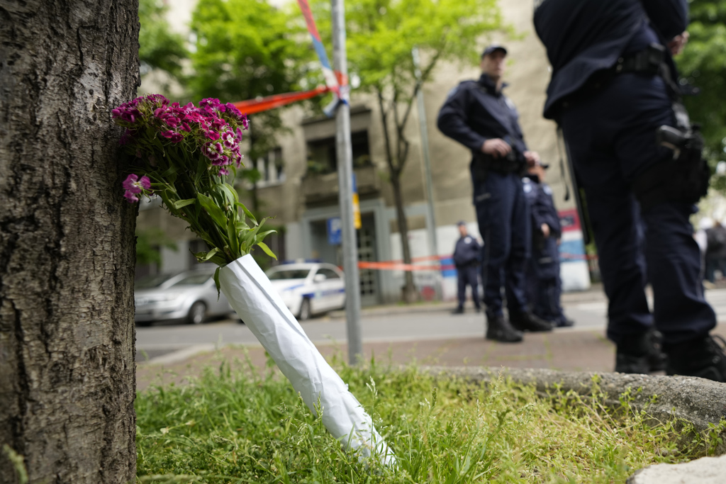 塞尔维亚首都一所学校3日发生大规模枪击案，当地民眾在校外摆放花束悼念死者。（图／美联社）