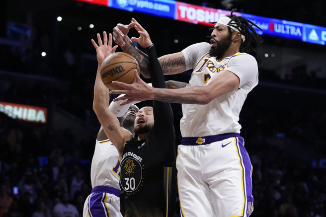 安东尼戴维斯（右）封阻柯瑞（中）投篮。（美联社资料照）