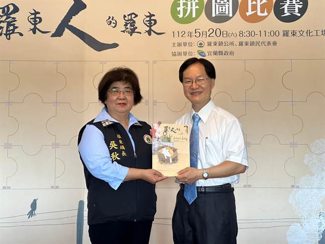 罗东镇长吴秋龄（左）致赠《罗东人的罗东》双语绘本给罗东高中校长曾璧光（右）。（罗东镇公所提供／吴佩蓉宜兰传真）