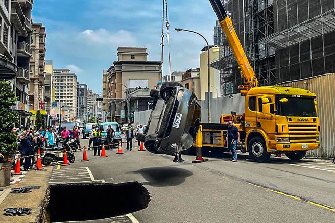 掉落天坑的特斯拉轿车被吊车吊起送维修厂，车商称报销。（罗浚滨摄）