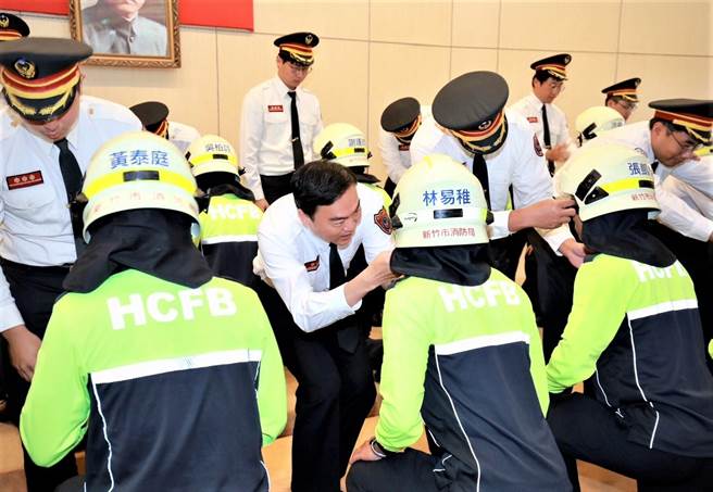新竹市消防局长李世恭领导师傅们为新生戴上消防帽。（新竹市消防局提供／王惠慧新竹传真）
