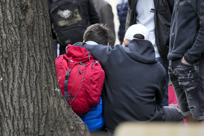 案发小学的学童坐在校外彼此安慰。（图／美联社）