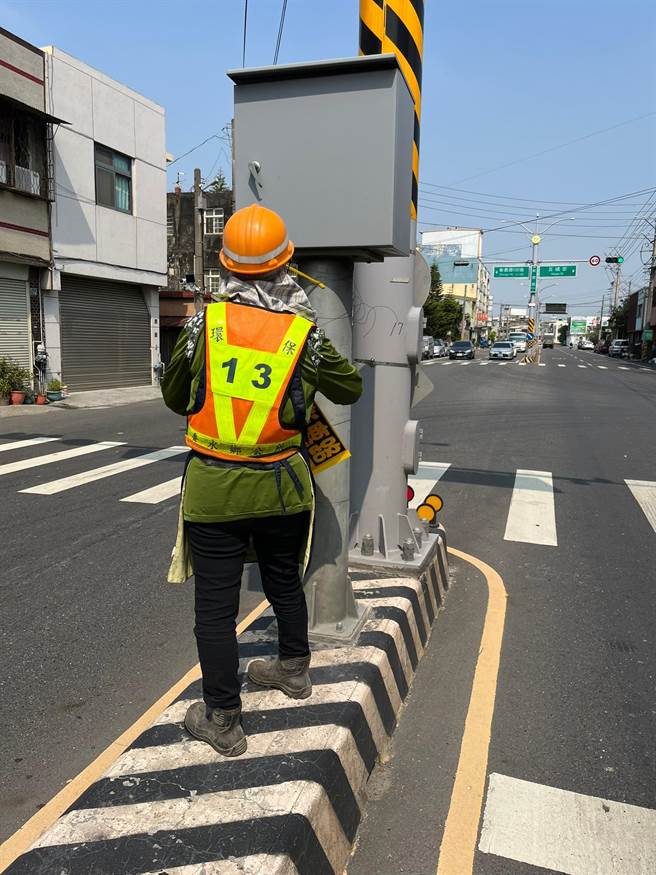清洁队在中央分隔岛清除违规小广告。（彰县府提供／孙英哲彰化传真）