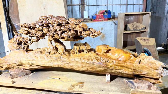 名木雕刻家林正發及其作品「母子情深」。(林正發工作室提供)