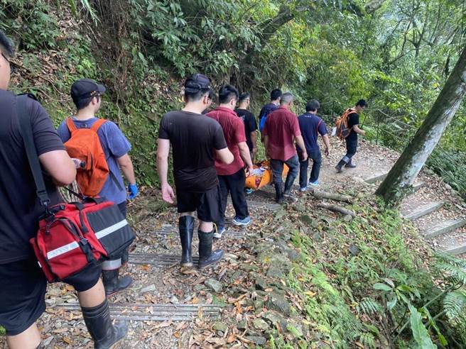 消防人员以担架合力将陈女搬运至森林游乐区入口。（消防局提供）