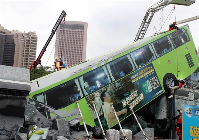 台北市民安9号演习，在溃缩车体脱困作业演练中，救难人员在变形的公车旁搜救受伤民眾。（郑任南摄）