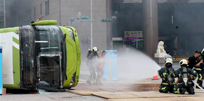 台北市民安9号演习，在大量伤病患演练中，救难人员在翻覆公车前洒水灭火并抢救伤患。（郑任南摄）