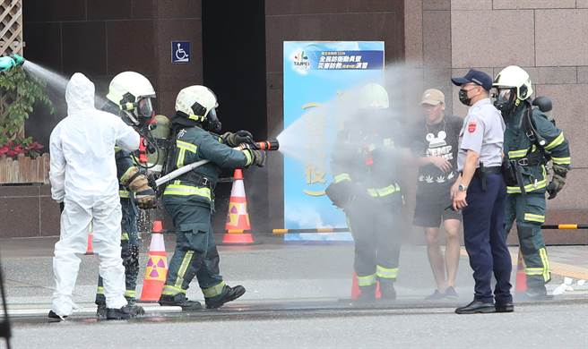 台北市民安9号演习，在战时核子辐射灾害演练中，抢救人员对可能沾染辐射污染的民眾与消防员洒水，减少污染程度。（郑任南摄）