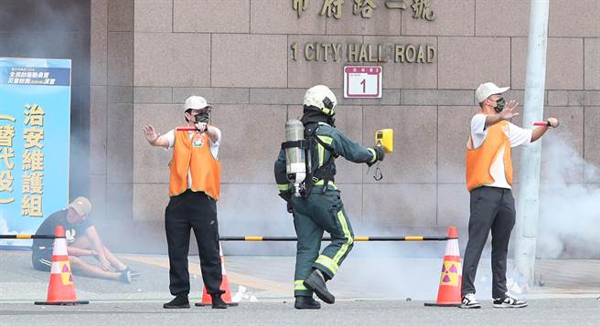 台北市民安9号演习，在战时核子辐射灾害演练中，首次参与演习的替代役男于灾害发生初期立即反应在灾难现场支援指挥交通，让消防队员检测现场的辐射污染程度。（郑任南摄）