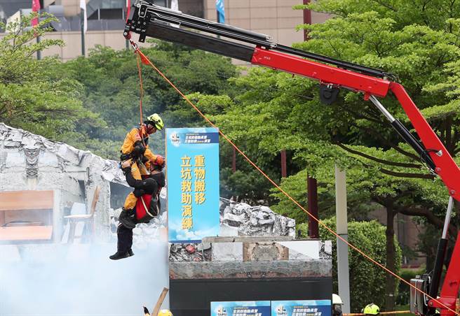 台北市民安9号演习，在倒塌建筑物人命搜救演练中，救难人员抵达现场后协助受困民眾脱困。（郑任南摄）