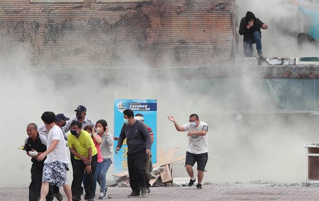 台北市民安9号演习，在倒塌建筑物人命搜救演练中，救难人员抵达现场后协助受困民眾脱困。（郑任南摄）