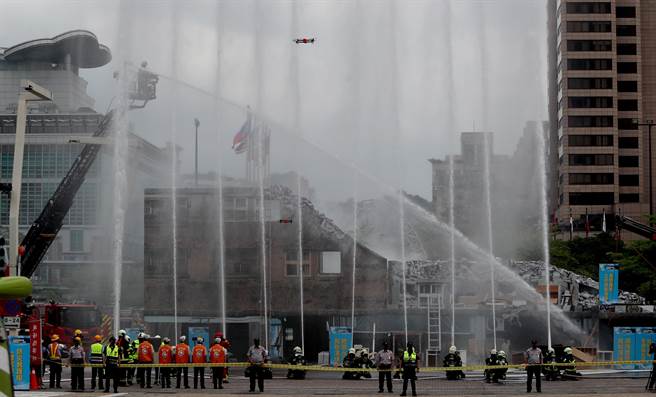 台北市民安9号演习，在倒塌建筑物人命搜救演练中，救难人员以强大的水柱配合无人机扑灭火势并搜寻受困民眾。（郑任南摄）