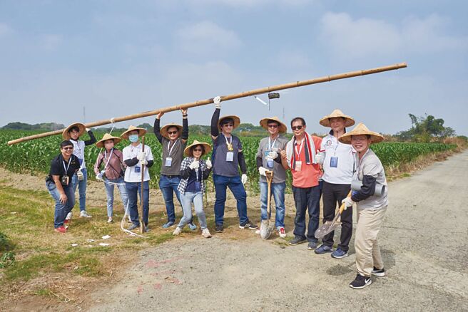 開發金控志工們協助農民整地，為「黑翅鳶」搭建棲架，支持環境互利共生的友善農法。圖／開發金控提供