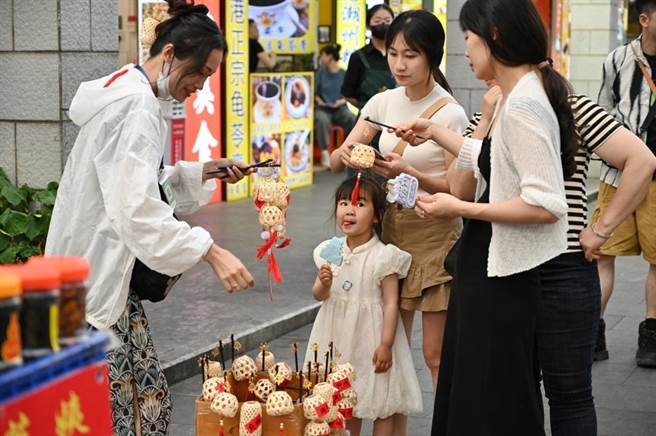 图为广东潮州古城牌坊街一摊位的特色竹灯笼吸引游客选购。（摘自中新社）