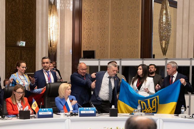 黑海经济合作会议4日在土耳其安卡拉举行大会，俄罗斯代表团副团长季莫费耶瓦（前排左二）发言时，乌克兰代表团团长离席抗议，其他成员在季莫费耶瓦后方展示旗帜、高呼反俄口号，俄方成员制止时双方发生推挤。（图／路透社）