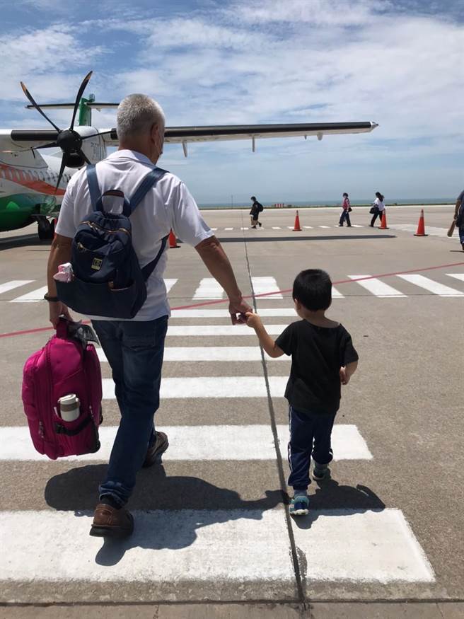 许永煌(左)日前专程搭机将「阿宝」(右)送到台湾交给认养父母，纵有百般不舍，也期许他能有更好的未来。(图／金门家扶中心提供)