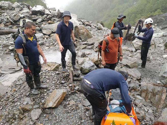 花莲县消防局与林务局人员，轮流搬运受伤女山友，山区地形相当艰困。（花莲县消防局提供／王志伟花莲传真）