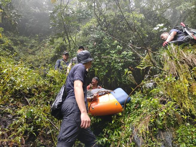花莲县消防局与林务局人员，轮流搬运受伤女山友，山区地形相当艰困。（花莲县消防局提供／王志伟花莲传真）