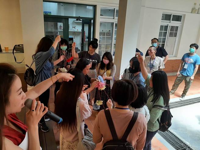 单身男女在士林公民会馆抽捧花牵出命中注定的对方，进行恋爱拍拍照小游戏。（士林区公所提供）