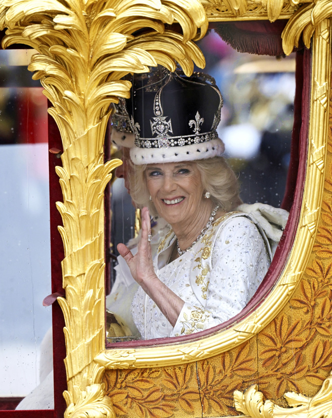 搭乘黄金马车返回白金汉宫的卡蜜拉笑容满面向群眾挥手。（图／美联社）