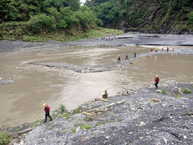 搜救人员发现受困登山客自行脱困下撤至孙海桥溪边，将受困人员以引度过河方式脱困。（读者提供／张妍溱台中传真）