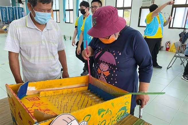 竹县推动青银同乐「公益青年送爱下乡趣」，长辈回味古早童玩打弹珠。（新竹县政府提供／罗浚滨新竹传真）