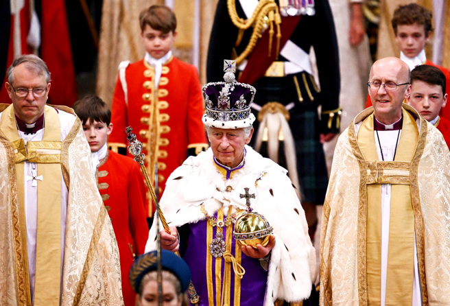 英国国王6日在西敏寺进行加冕时，许多网友反而特别关注在门口快速通过的黑影，讥讽是「死神」降临，不过西敏寺澄清，只是教堂司事经过。图为查尔斯完成加冕仪式，准备离开西敏寺。（图／路透社）