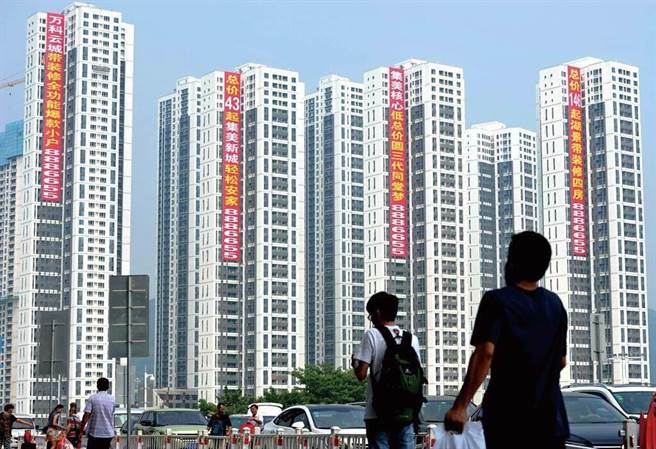 圖為廈門市民從正在銷售的萬科樓盤旁經過。（資料照／中新社）