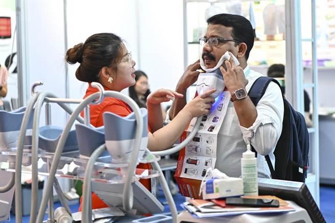 一名外国採购商在日前登场的广交会上体验一款美容仪。（摘自中新社）