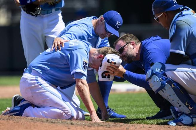 皇家先发投手亚布洛(左)遭到打者强袭球击中。（美联社）