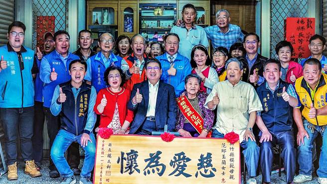 县长杨文科（中）致赠牌匾等礼物给关西镇91岁模范母亲范邱玉兰。（新竹县政府提供／罗浚滨新竹传真）