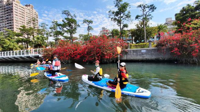 高雄推动还河于民政策，民眾于爱河体验SUP活动。(高雄市观光局提供)