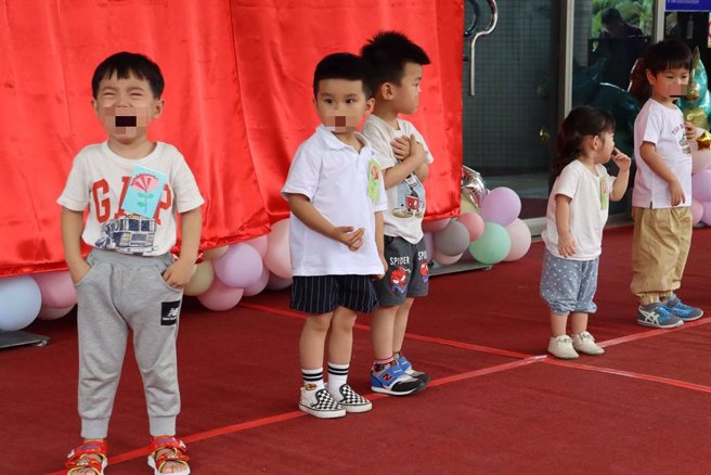 揭牌仪式上，小小孩有的放声大哭、有的显得不知所措，反应真实。（吕妍庭摄）