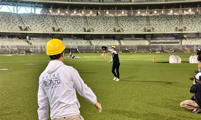 国民党议员詹为元（左）与民眾党议员陈宥丞（中间黑衣者），9日于大巨蛋内野进行传接球，尔后表示确实会因为座椅顏色而有「吃球」的状况。（丁上程摄）