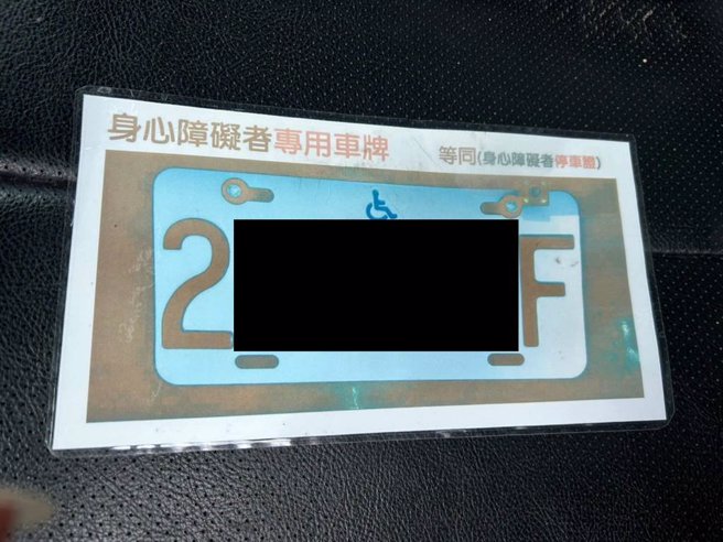 云林县障友林金顺将「身心障碍者专用车牌」影印并放大置于车上，凸显专用车牌须要改进的地方。（张朝欣摄）