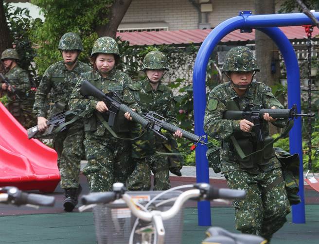 国军首批志愿接受教育召集的14位女性后备军人，9日在桃园八德地区地区实施城镇战操练，随战斗支援连在巷弄中奔跑出枪，模拟为后续开到的大部队抢占地形。（陈怡诚摄）