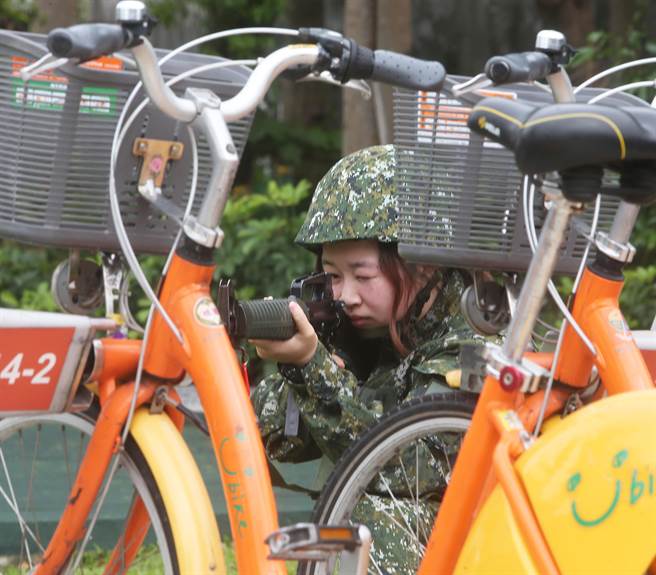 国军首批志愿接受教育召集的14位女性后备军人，9日在桃园八德地区地区实施城镇战操练，随战斗支援连利用巷弄地形出枪，模拟为后续抵达大部队抢占地形。（陈怡诚摄）