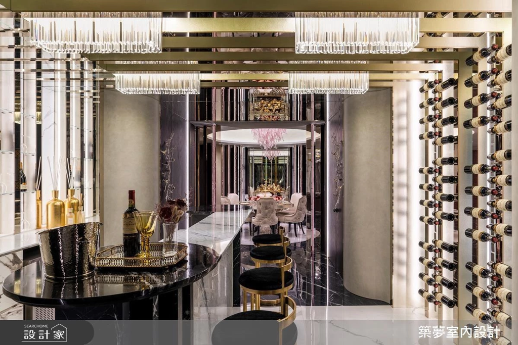設計師在鈦金屬的俐落框架之間，綴入水晶燈與鏡面材質，隨著光線的反射穿梭和重疊的空間線性，在連結餐廳與庭院的過渡地帶，打造出高級奢華的酒廊吧檯。(圖/searchome設計家)