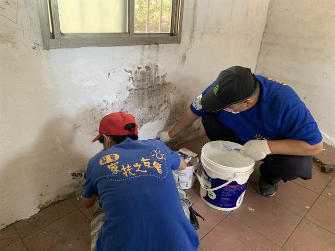 志工仔細進行每道工序，粉刷前先補土。(屏東家扶提供)