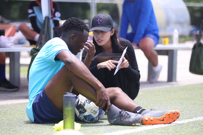 台湾石虎FC副领队苗广雅（右）在训练场向肯亚外援万亚马说明发薪细节。（李弘斌摄）