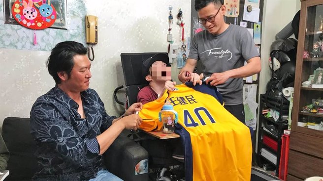 王建民（左）送脑麻儿粉丝翔翔（中）亲笔签名周边。（公视提供）