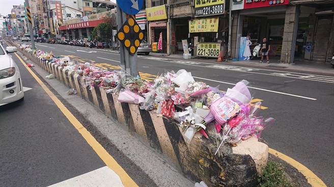 追悼车祸丧命3岁女童，民眾把鲜花与玩具放在安全岛上，不过被风吹落反增危险，女童的父亲呼吁民眾别再前往放悼念品。（程炳璋摄）