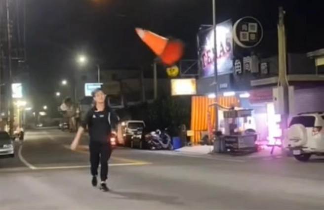 一名年轻人在大马路上丢掷三角锥。（翻摄彰化踢爆网／孙英哲彰化传真）