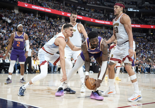 太阳中锋Deandre Ayton(中)持球遭到金块球员包围。（美联社）