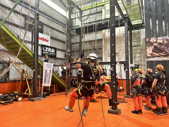 新北市内丰富的自然环境和公共设施成为了本次的天然训练场，从高楼建筑物、桥梁、多变的山域及地下设施等场域模拟救援任务，让学员在实战情境中熟练个人须掌握绳索技巧和操作方法及作战小组的分工与团队合作，进而提升救援效率。（图／消防局提供）